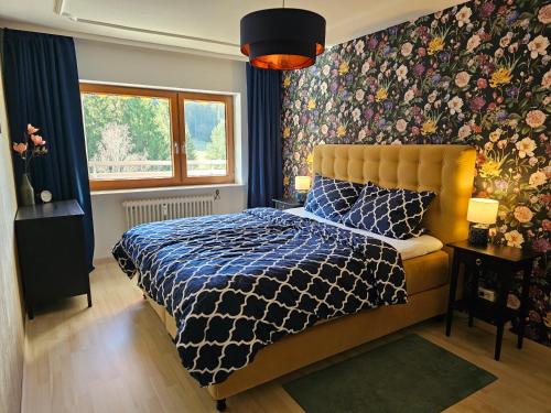 una camera con letto e parete floreale di Ferienwohnung Tannenballett im Schwarzwald a Baiersbronn