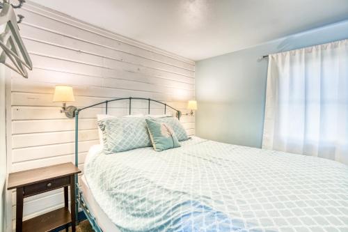 a bedroom with a bed with a blue and white comforter at Hidden Villa Cottage #4 - The Ocean Cottage in Cannon Beach