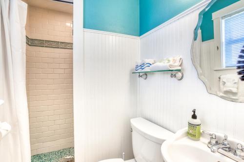 a bathroom with a toilet and a sink and a mirror at Hidden Villa Cottage #4 - The Ocean Cottage in Cannon Beach