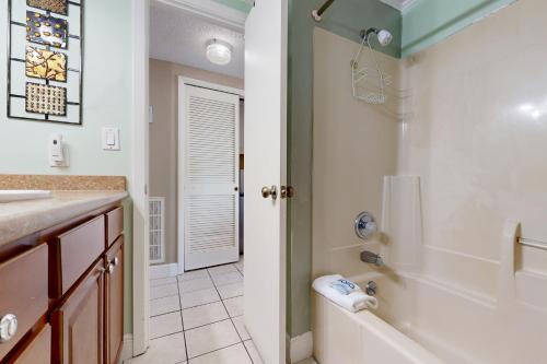 une salle de bain avec une baignoire, une douche et un lavabo dans l'établissement Pirates Bay A310, à Fort Walton Beach