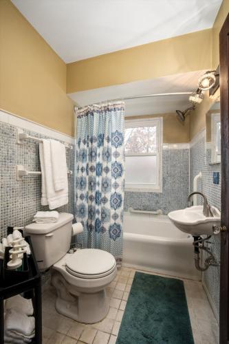 a bathroom with a toilet and a sink and a tub at 10 Mins To The Big House and Sleeps Up To 10 Guests in Ann Arbor