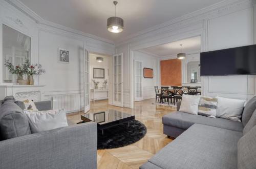 un soggiorno con due divani e un tavolo di 120 m2 Luxury Eiffel Signature a Parigi