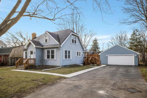 a blue house with a white garage at 10 Mins To The Big House and Sleeps Up To 10 Guests in Ann Arbor