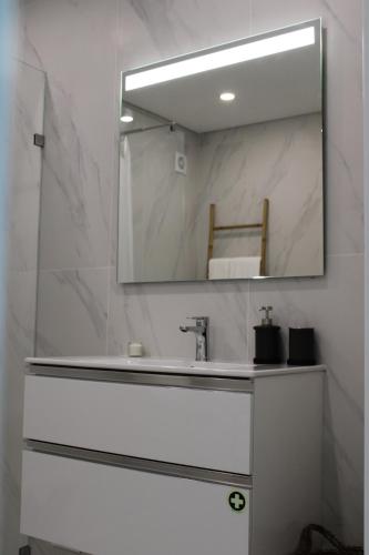un baño con lavabo y espejo en Alto Mar Apartment 2, en Atouguia da Baleia
