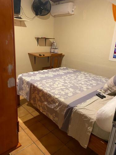 Cama pequeña en habitación con mesa en Carpediem, en La Trinité