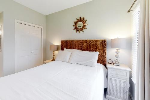 una camera da letto bianca con un letto grande e uno specchio di Tidewater 906 a Orange Beach