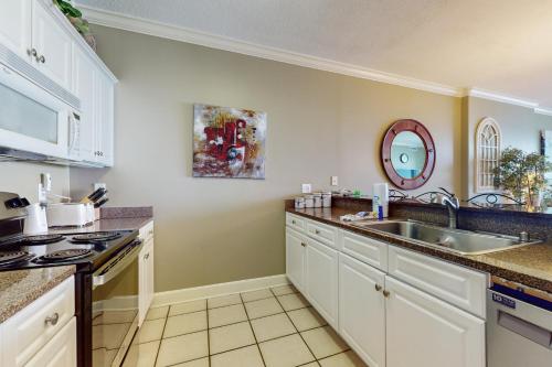 a kitchen with white cabinets and a sink at Regency Isle 903 in Perdido Key