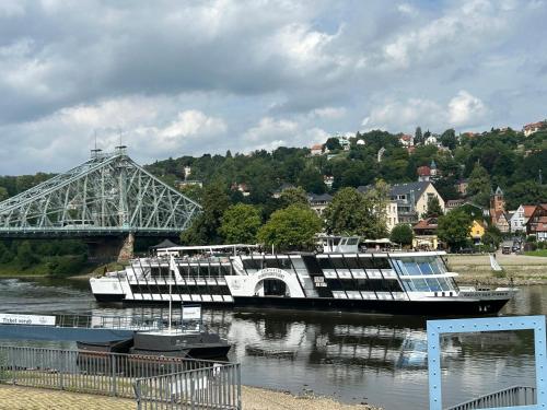 a boat is docked on the river near a bridge at Boutique Hotel am Schillerplatz in Dresden