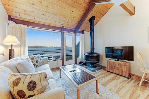 a living room with a couch and a fireplace at Embarcadero on the Water #G146 in Newport