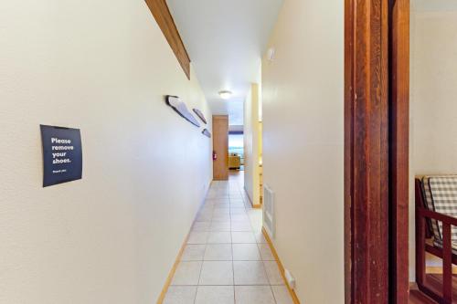 a hallway with a white wall with a sign on it at Embarcadero on the Water #G146 in Newport