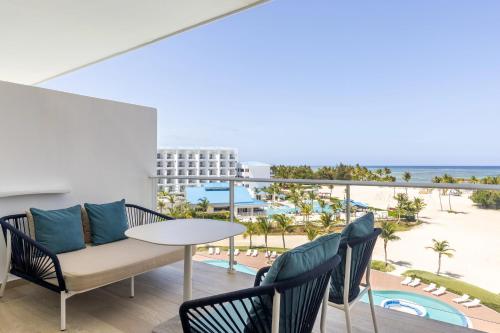 a balcony with a table and chairs and a view of the beach at Dreams Cap Cana Resort & Spa - All Inclusive in Punta Cana