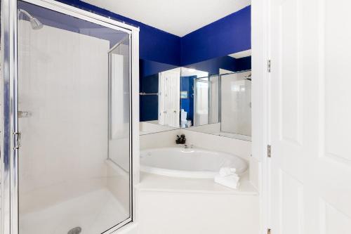 a bathroom with a tub and a shower with blue walls at Regency Isle 805 in Perdido Key