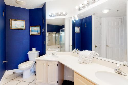 a bathroom with blue walls and a toilet and a sink at Regency Isle 805 in Perdido Key