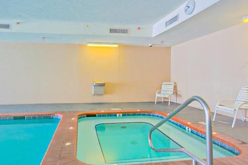 a swimming pool in a room with chairs and tables at Regency Isle 805 in Perdido Key