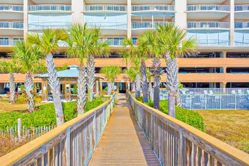 a walkway with palm trees in front of a building at Regency Isle 805 in Perdido Key