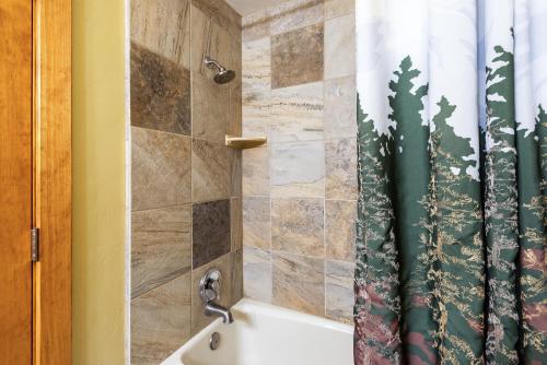 Un baño con bañera y cortina de ducha. en Mountain Village Studio #225, en Park City