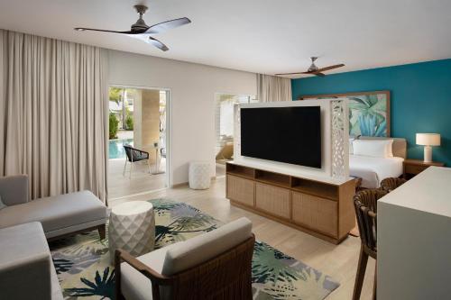 a living room with a television and a bedroom at Dreams Cap Cana Resort & Spa - All Inclusive in Punta Cana