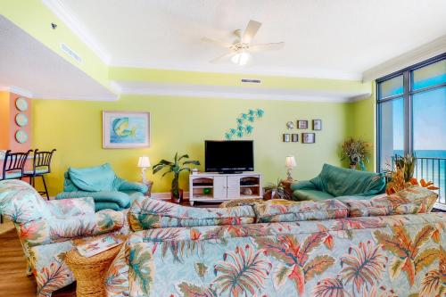 a living room with a couch and a tv at Phoenix West 502 in Romar Beach