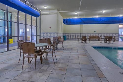 a pool room with tables and chairs next to a pool at Phoenix West 502 in Romar Beach