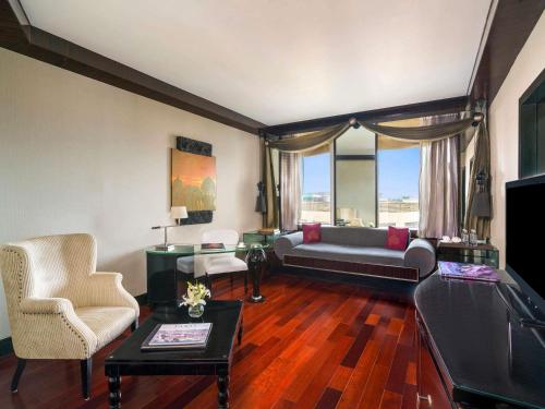 a living room with a couch and a television at Sofitel Mumbai BKC in Mumbai