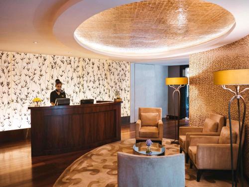 a man sitting at a desk in a hotel lobby at Sofitel Mumbai BKC in Mumbai