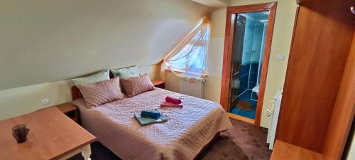 una pequeña habitación con una cama y una mesa en U Nazara, en Slavske