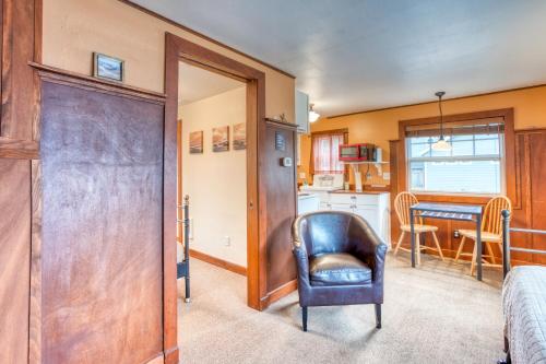 a living room with a chair and a kitchen at Hidden Villa Cottage #6 - The Starfish Cottage in Cannon Beach