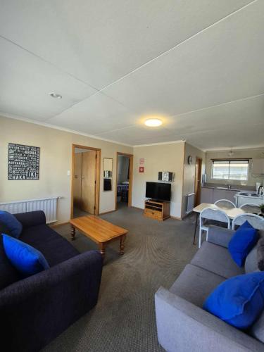 a living room with two couches and a table at Alexandra Motor Lodge NZ in Alexandra