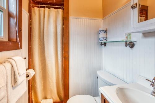 a bathroom with a shower curtain and a toilet at Hidden Villa Cottage #6 - The Starfish Cottage in Cannon Beach