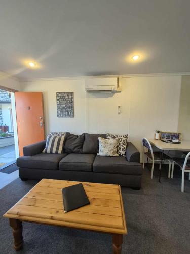 a living room with a couch and a table at Alexandra Motor Lodge NZ in Alexandra