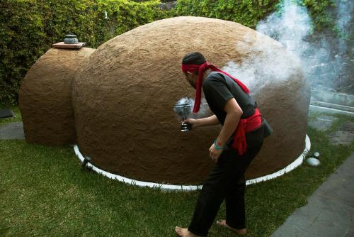 a man standing in front of a large rock at Hotel Boutique Casa Fernanda in Tepoztlán