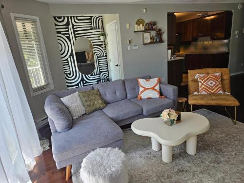 ein Wohnzimmer mit einem blauen Sofa und einem Tisch in der Unterkunft Boho Retreat 3BD Condo Close to Ottawa in Gatineau