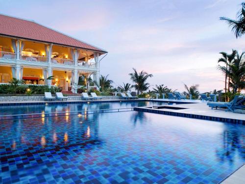 a swimming pool in front of a building at La Veranda Resort Phu Quoc - MGallery in Phu Quoc