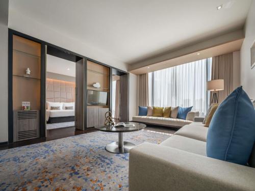 a living room with a couch and a table at VIE Hotel Bangkok - MGallery Collection in Bangkok