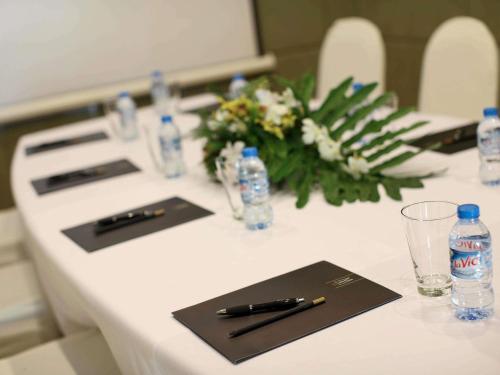 a white table with bottles of water and a pen on it at La Veranda Resort Phu Quoc - MGallery in Phu Quoc