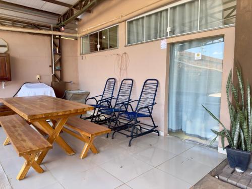 un patio avec une table et des chaises en bois dans l'établissement Nalevaiko- Apto Completo com Suíte e Garagem sinop, à Sinop