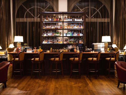 a bar in a restaurant with bar stools at Sofitel Phnom Penh Phokeethra in Phnom Penh