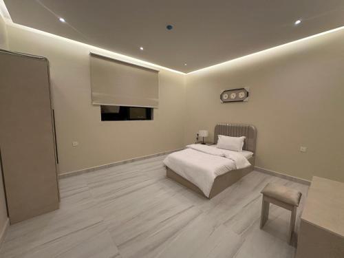 a bedroom with a bed and a table in it at الواجهة in Buraydah