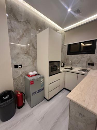a kitchen with white cabinets and a counter top at الواجهة in Buraydah