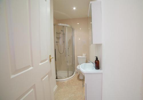 a white bathroom with a shower and a sink at The Sovereign in Whitstable