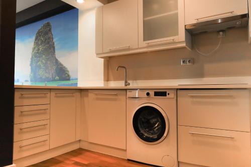 a laundry room with a washing machine in a kitchen at Qafqaz Baku Residence &Apartment in Mekhrably