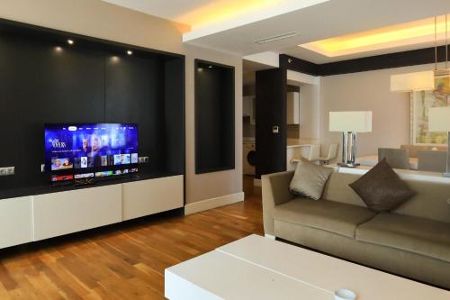 a living room with a couch and a flat screen tv at Qafqaz Baku Residence &Apartment in Mekhrably