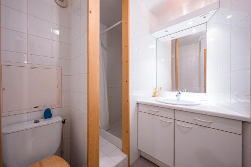a bathroom with a sink and a toilet and a mirror at Magnifique Appart Duplex Valthorens in Val Thorens