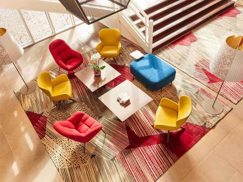 an overhead view of a living room with colorful chairs at Cabot Hotel Bordeaux - MGallery Collection in Le Pian-Médoc