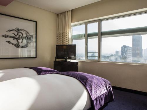 a hotel room with two beds and a large window at Sofitel Casablanca Tour Blanche in Casablanca