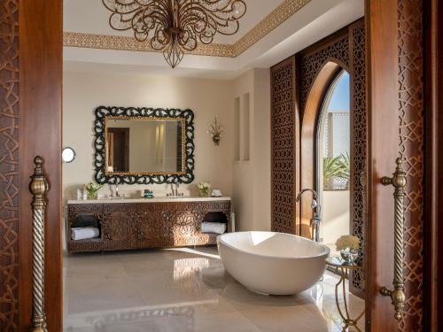 a bathroom with a large tub and a mirror at Sofitel Bahrain Zallaq Thalassa Sea & Spa in Manama