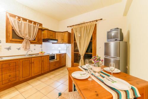 a kitchen with a wooden table and a refrigerator at Grekis Beach Hotel and Apartments in Petalidhion