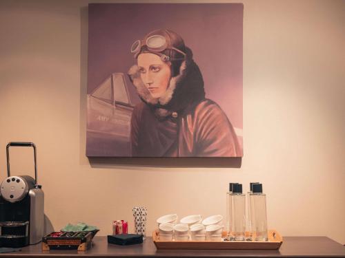 a painting of a woman with glasses on her head on a wall at Royal Emeraude Hotel Dinard - MGallery Collection in Dinard