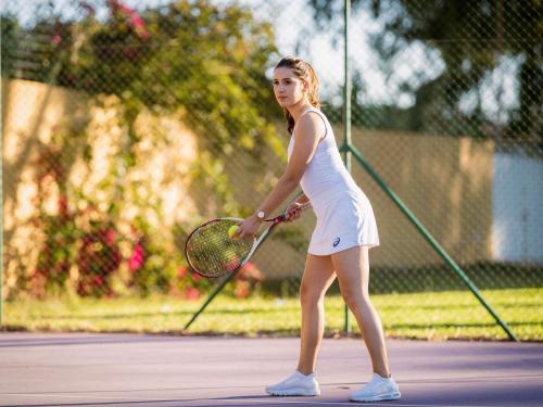 a woman holding a tennis racket on a tennis court at Sofitel Rabat Jardin Des Roses in Rabat