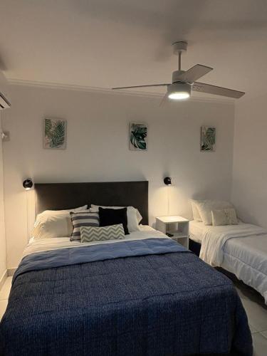 a bedroom with two beds and a ceiling fan at Pura Vida Concordia in Concordia